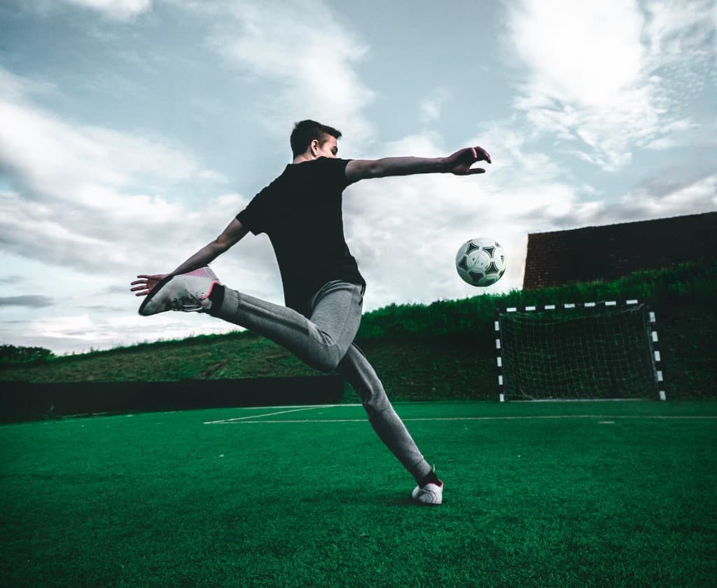 Soccer player striking a ball on a pitch